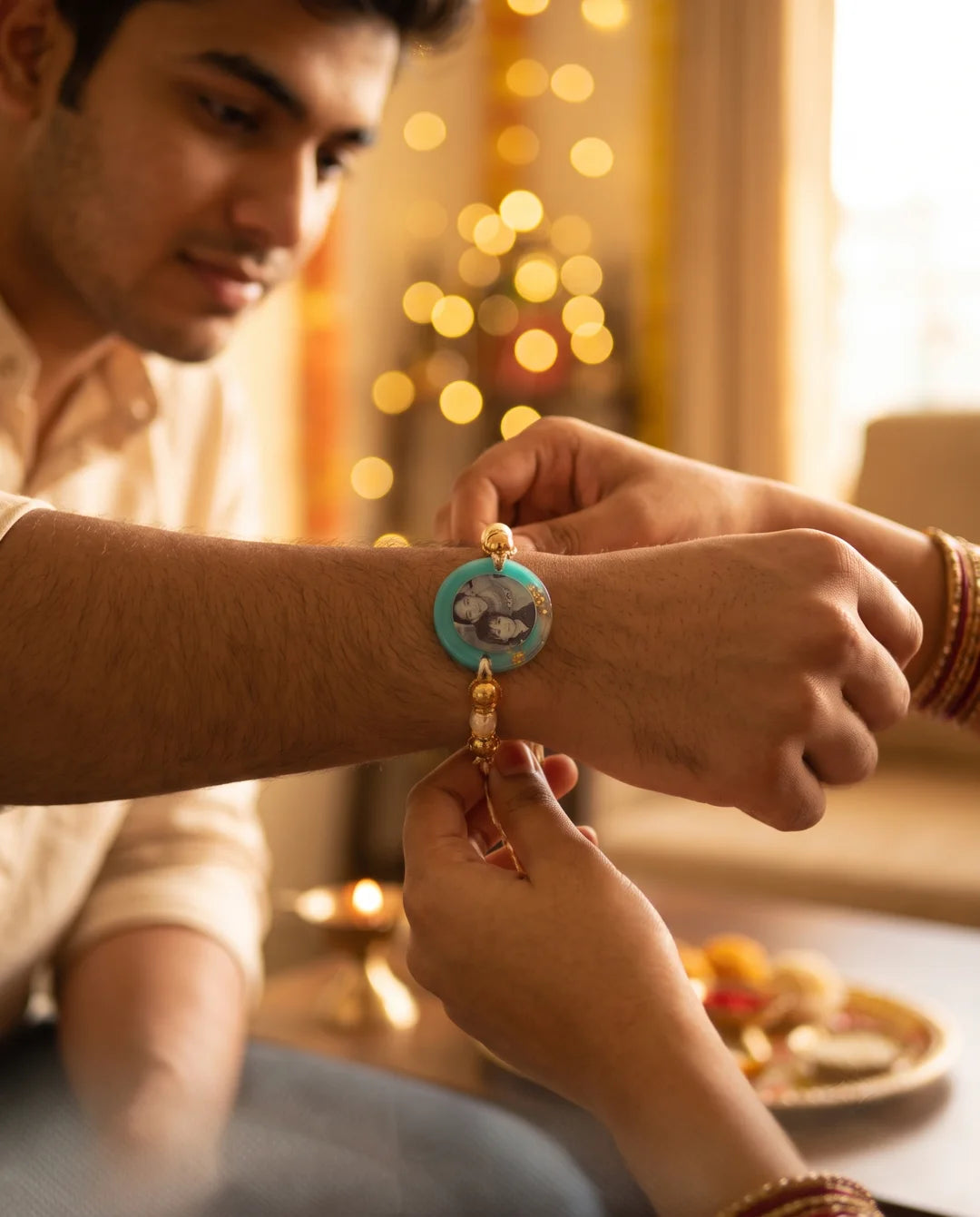 A personalised photo rakhi being tied on the wrist